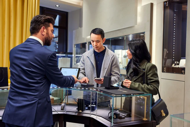 A couple at a jewelry store counter paying for earrings using Adyen's P400 terminal.