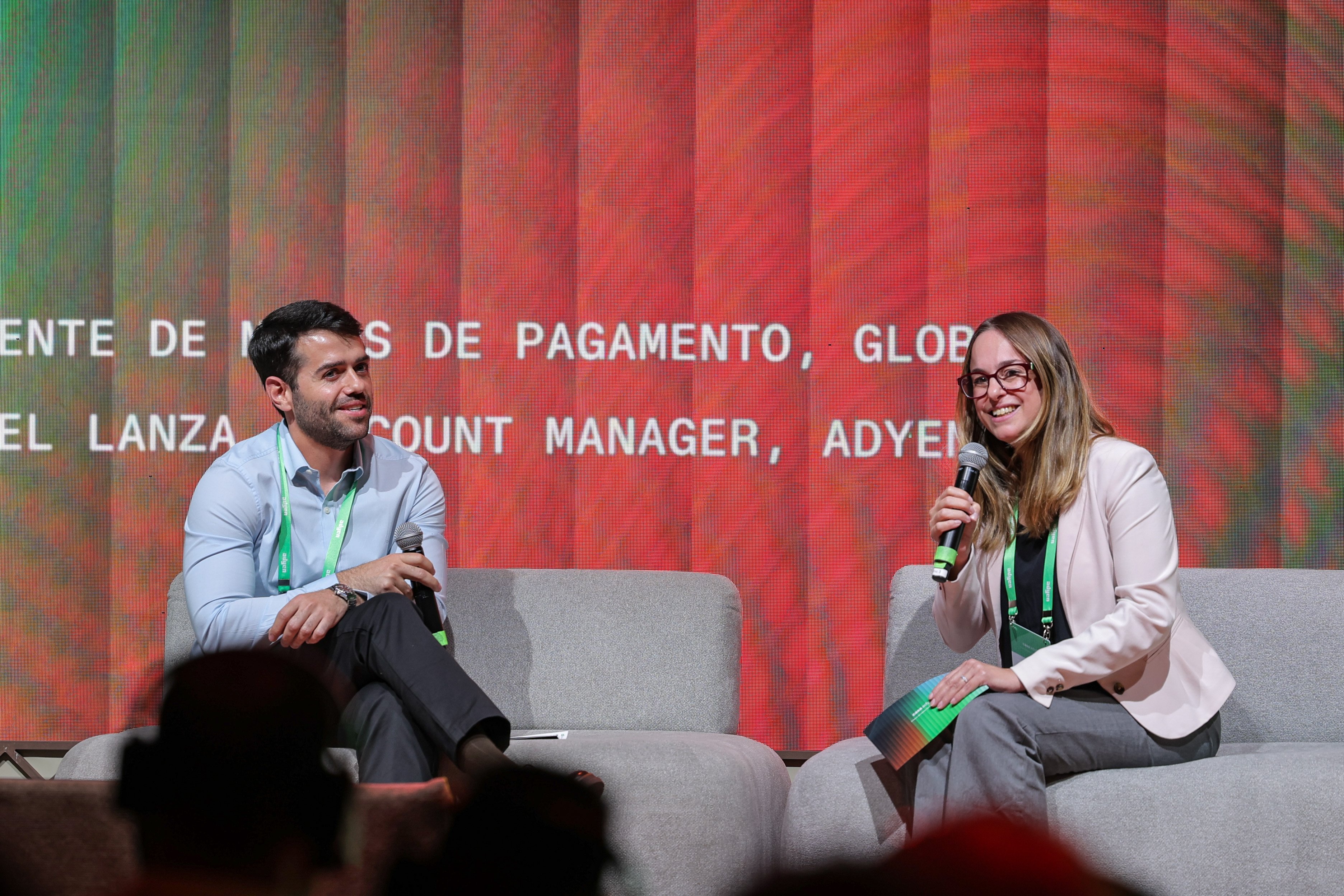 Equipe da Adyen discursando no palco durante apresentação em um evento.