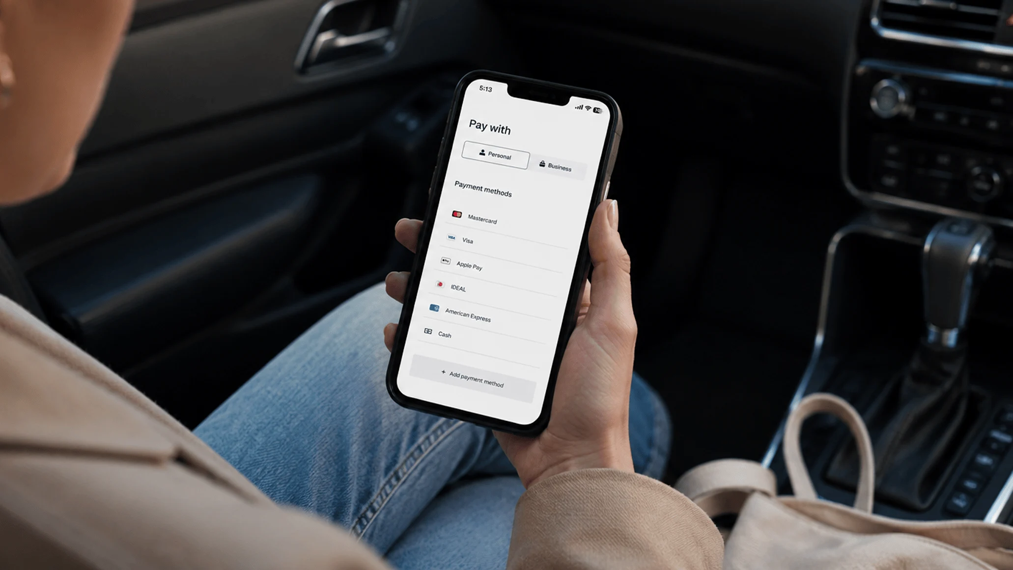 A customer using a smartphone to make a payment with an Adyen terminal in the background.