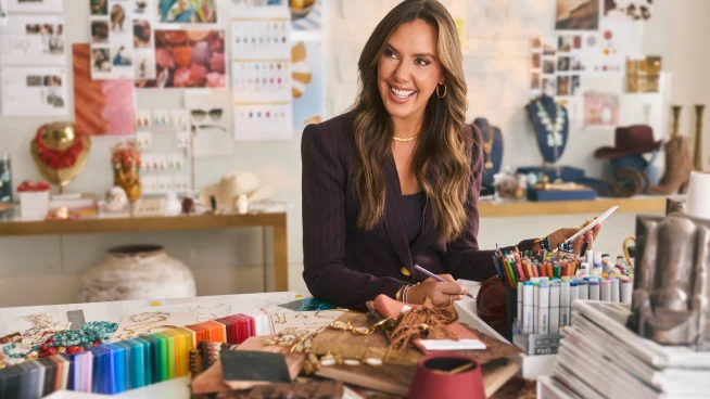 Creative workspace with fabric samples, color swatches, and design tools on a table.