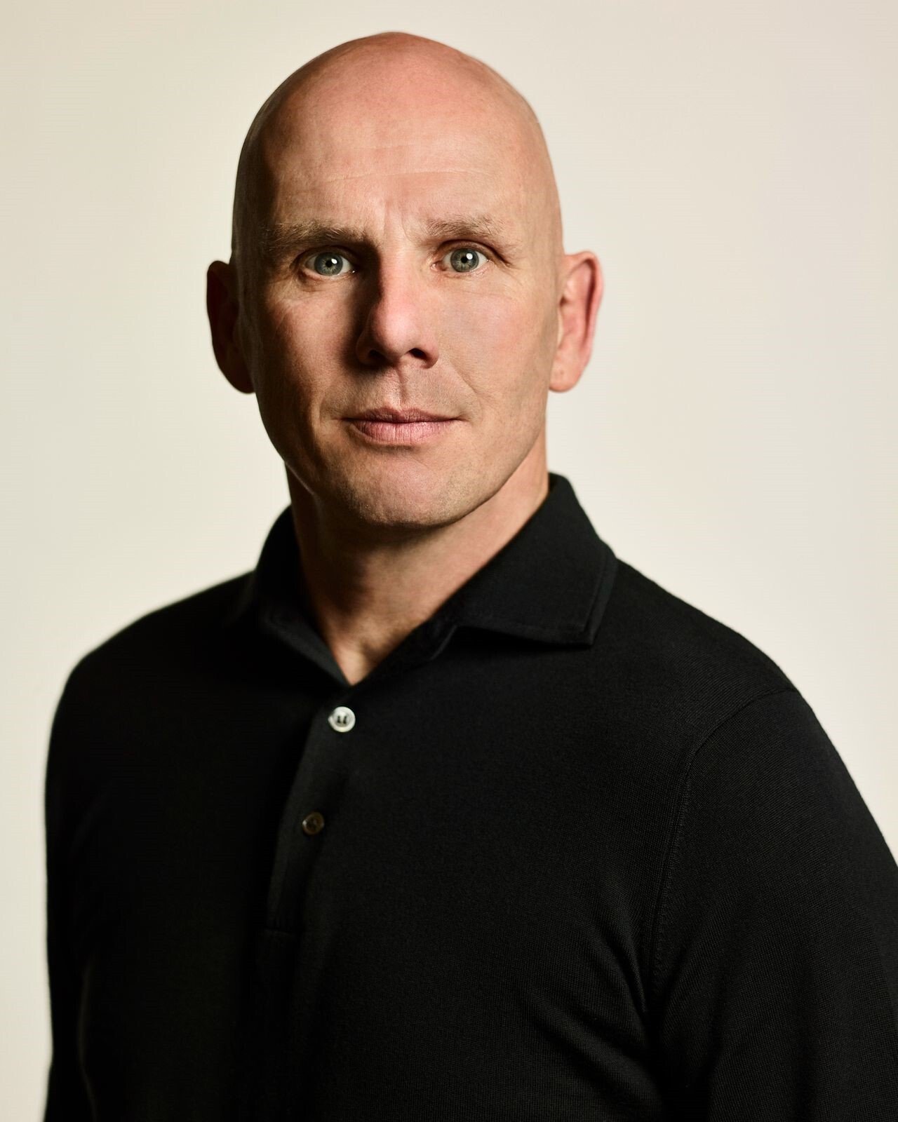 Adyen employee in an office wearing a black shirt, looking directly at the camera.