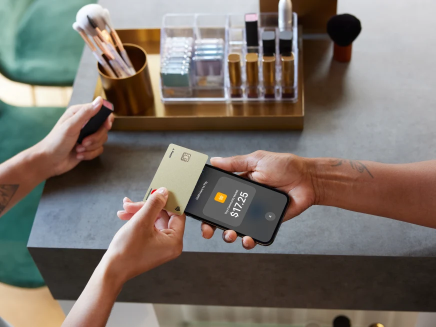 A customer pays with an Adyen card terminal in a modern retail setting.