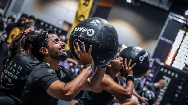 Miembros del equipo de Adyen entrenando con balones medicinales en una clase de fitness.