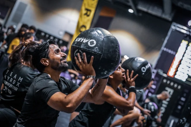 Adyen team members performing a workout with weighted balls in a fitness class.