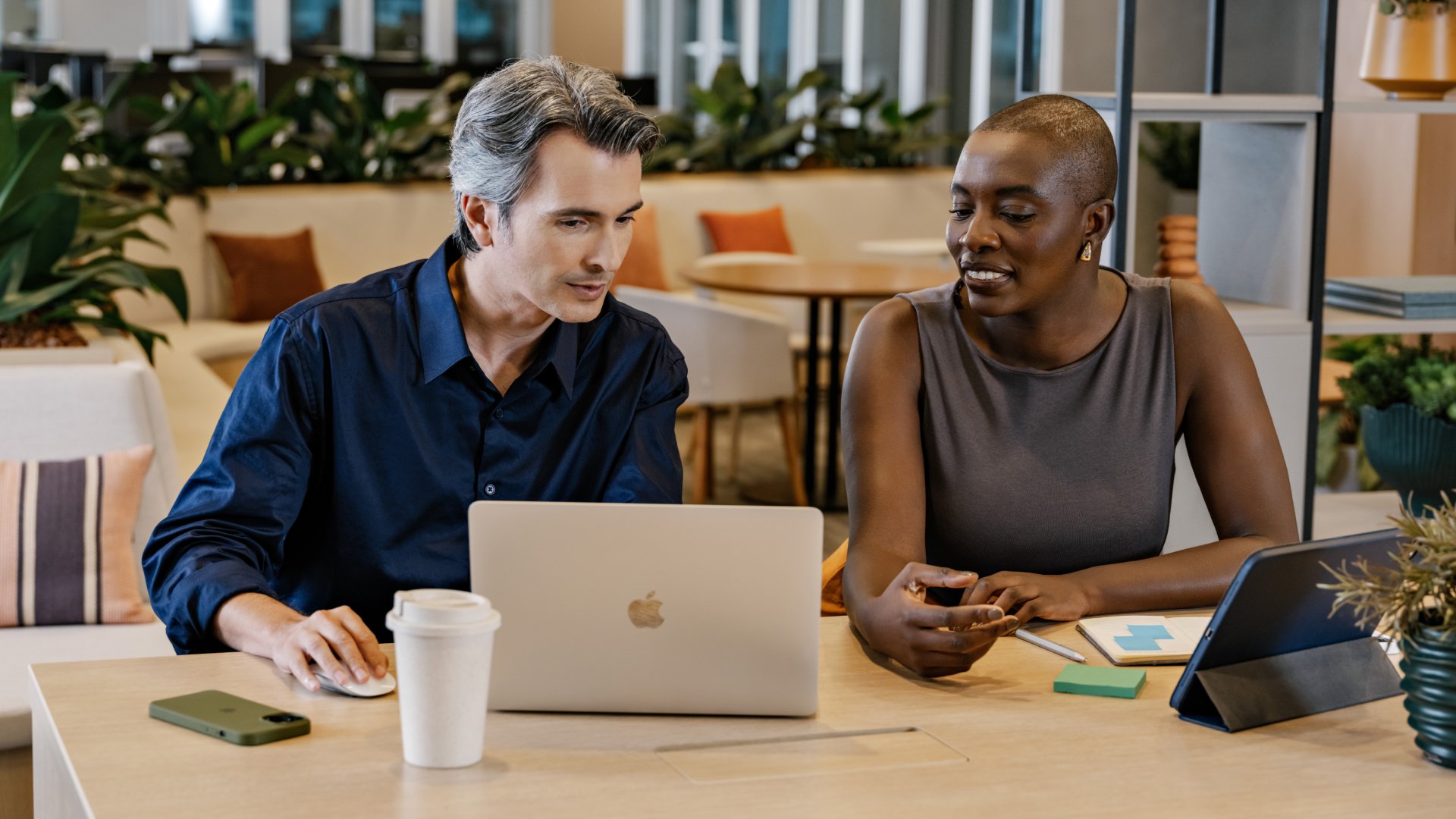 Adyen team members collaborating at a workspace with laptops and tablets.