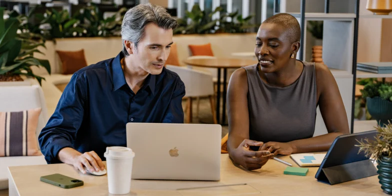 Adyen team members collaborating at a workspace with laptops and tablets.