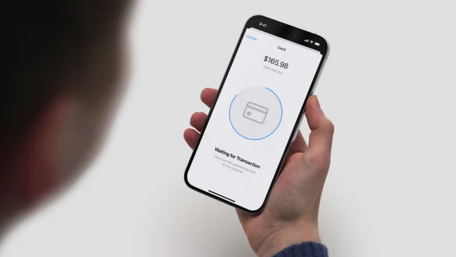 A customer making a payment using a mobile payment app on a smartphone with Adyen payment confirmation.