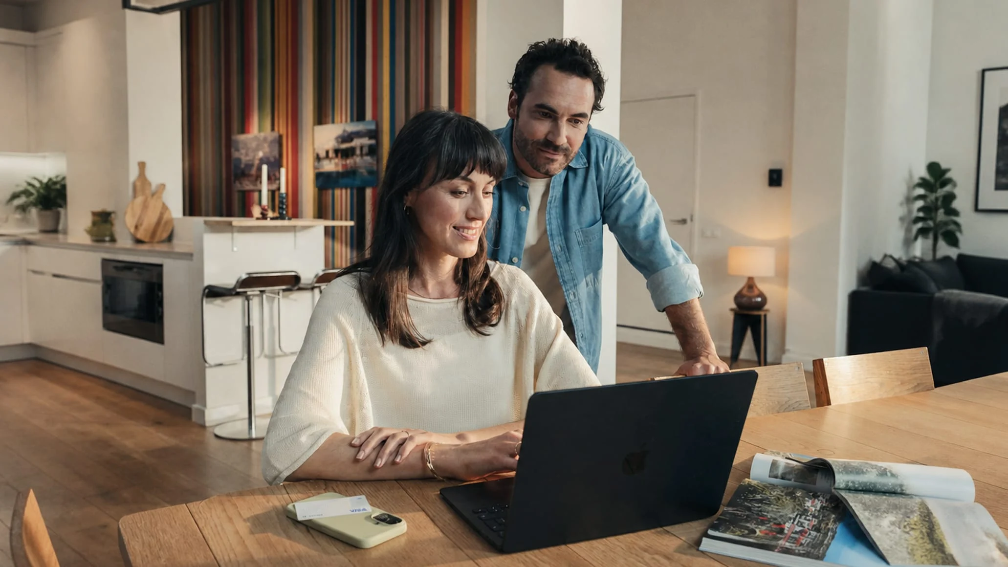 Adyen employees in the office review a laptop screen during a business meeting.