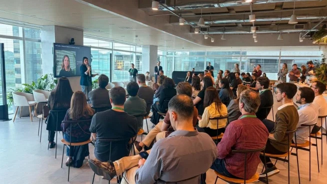 Apresentação corporativa em escritório moderno com público, palestrante e tecnologia de pagamentos Adyen.