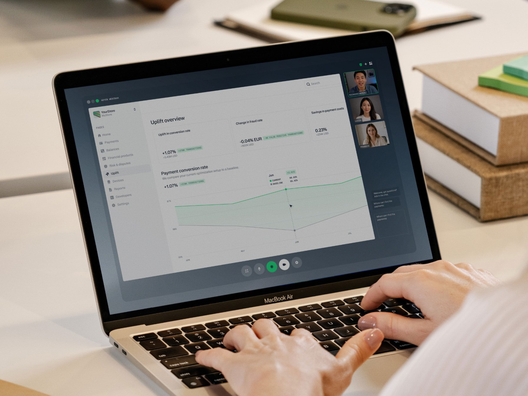 Adyen team members review transaction analytics on a laptop during a remote meeting.