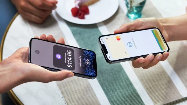 Two people tapping smartphones to process a contactless payment with Adyen app displaying the amount.