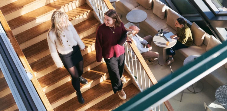 Adyen team members walking in the office corridor, with workspaces visible nearby.