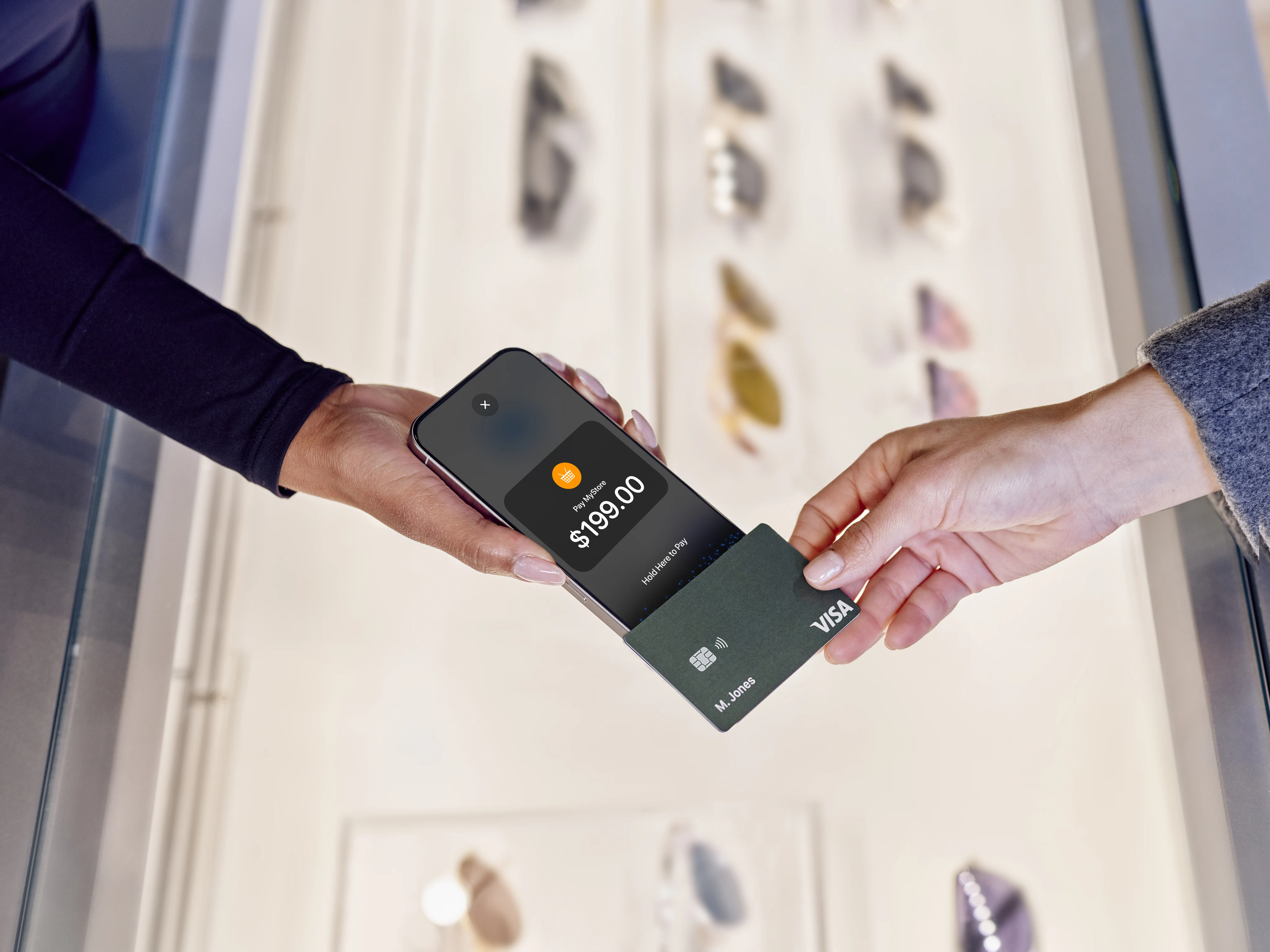 Person using a mobile device with a digital payment card at a retail terminal displaying an Adyen payment interface