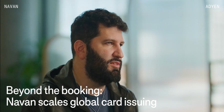 Adyen employee in an office with a screen displaying text about Navan and global card issuing.