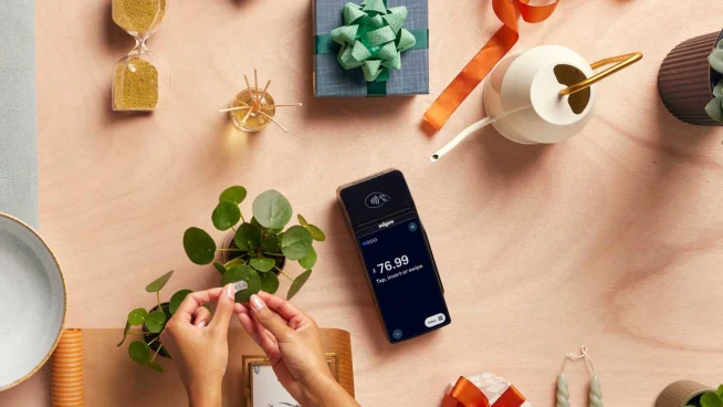 Manos envolviendo un tallo de planta con un lazo, al lado de un smartphone que muestra el pago de Adyen de $76.99.