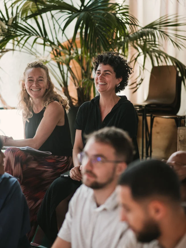 Adyen team members laughing and engaging at a meeting in a bright office setting