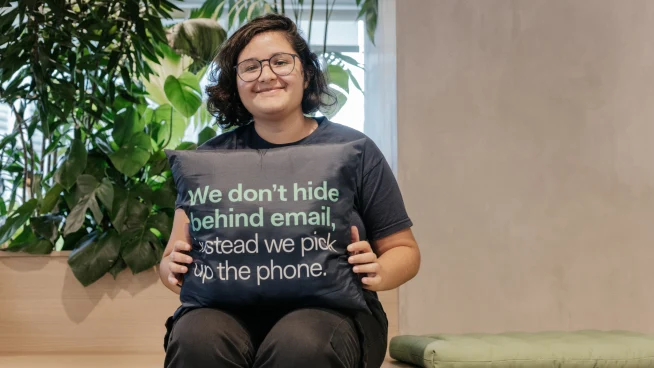 Funcionário da Adyen segurando um travesseiro com a fórmula