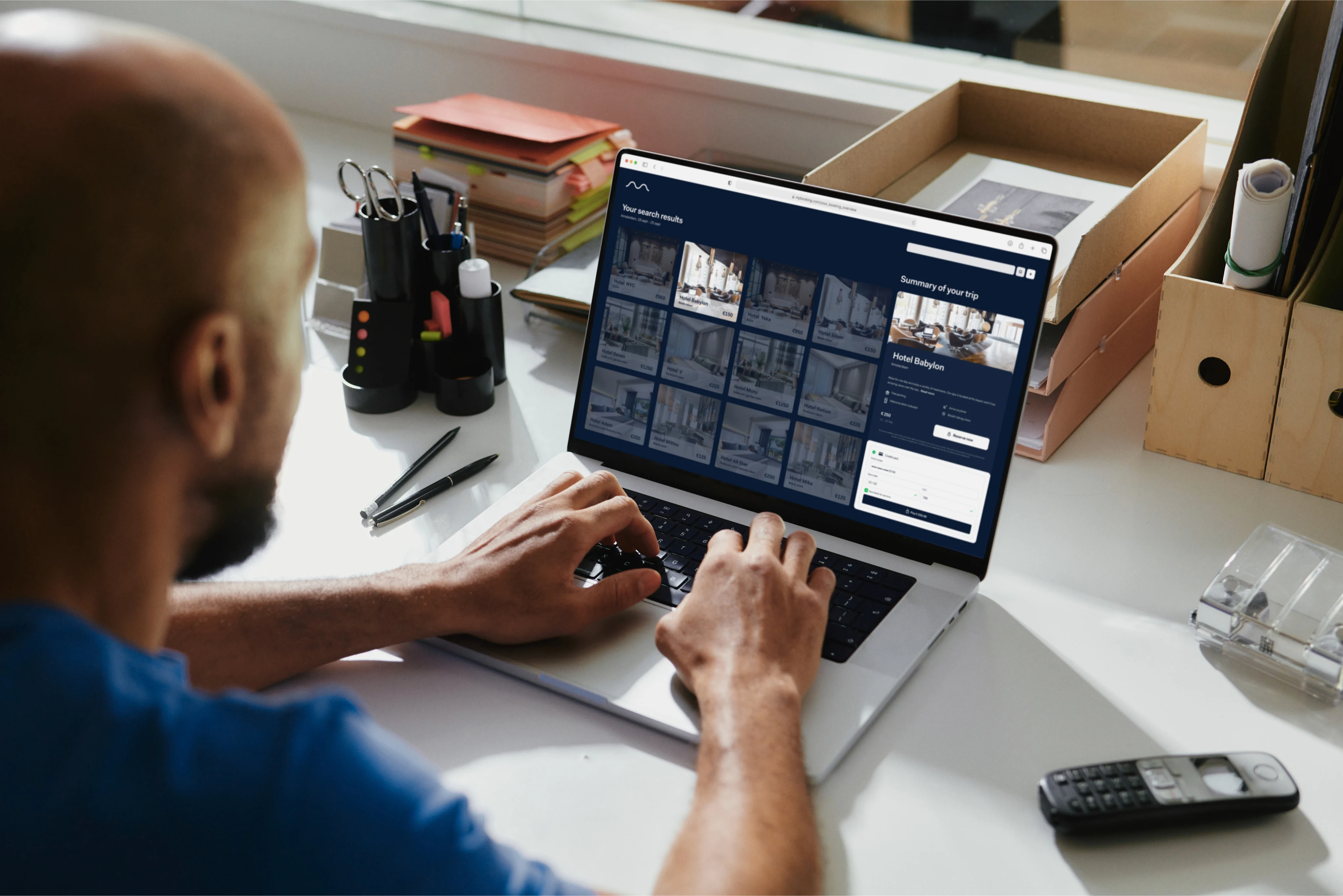 A man in front of a laptop, making a hotel booking using an online travel agency (OTA) booking system.