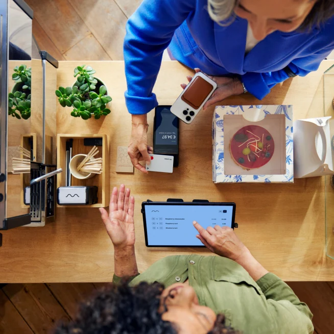 A customer in a coffee shop paying by card using Adyen's S1F2 terminal through a SaaS platform for food & beverage