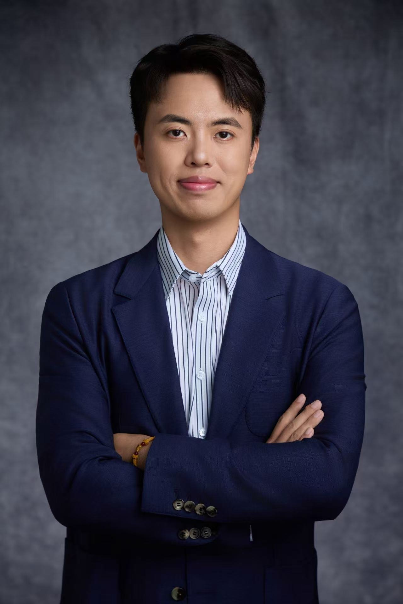 Adyen team member in a business suit with folded arms against a neutral background