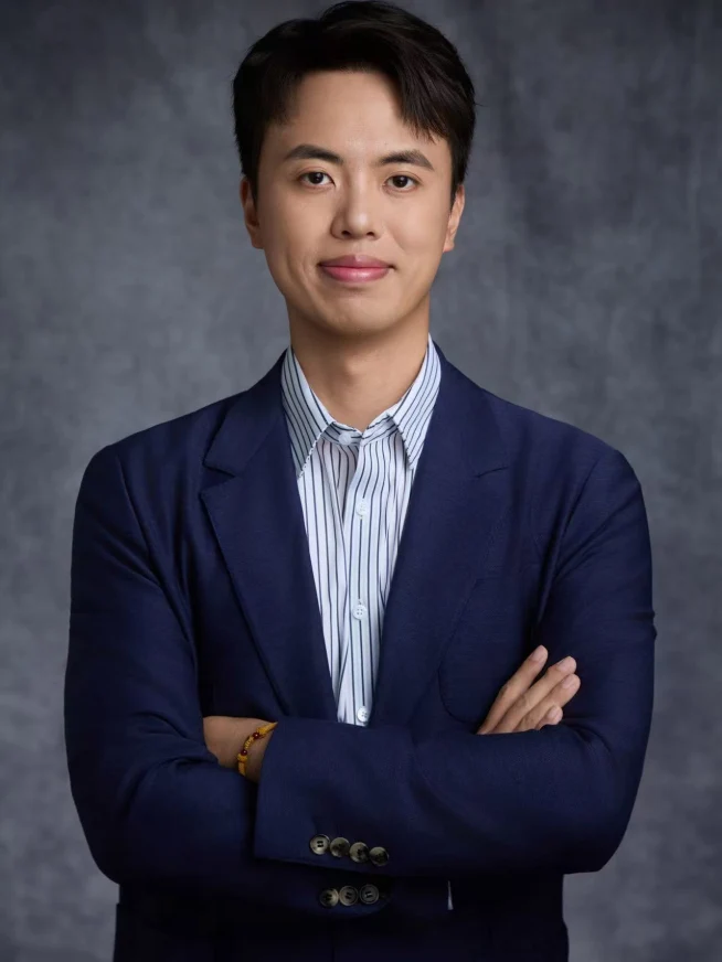 Adyen team member in a business suit with folded arms against a neutral background