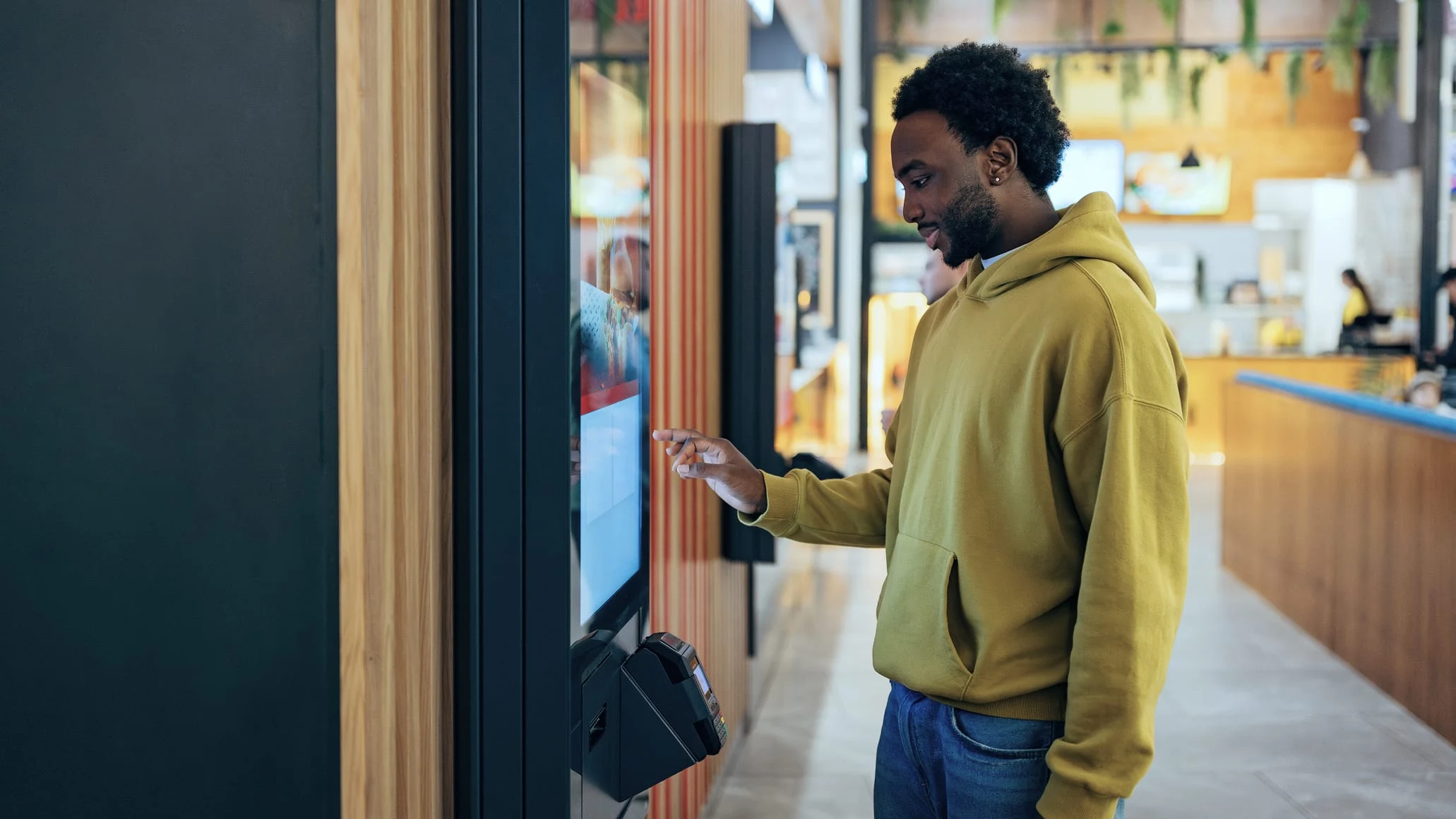 A customer using a payment terminal provided by Adyen in a retail setting.