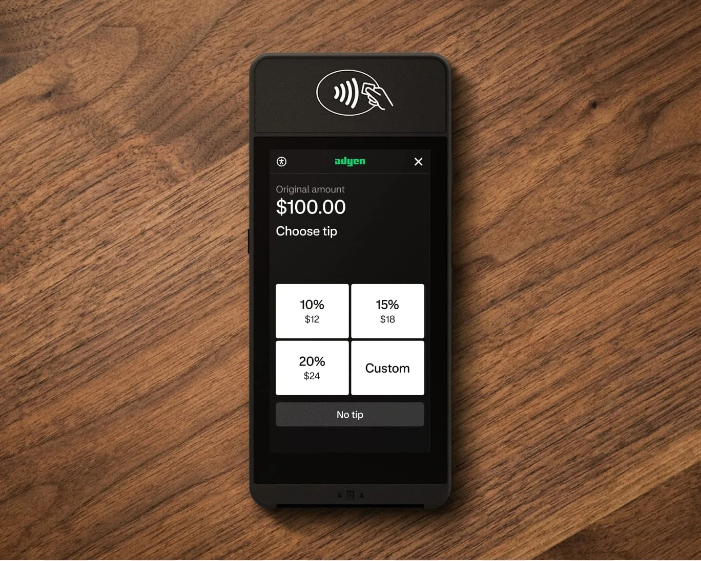 A payment terminal displaying tip options and total amount, with a contactless payment symbol at the top.