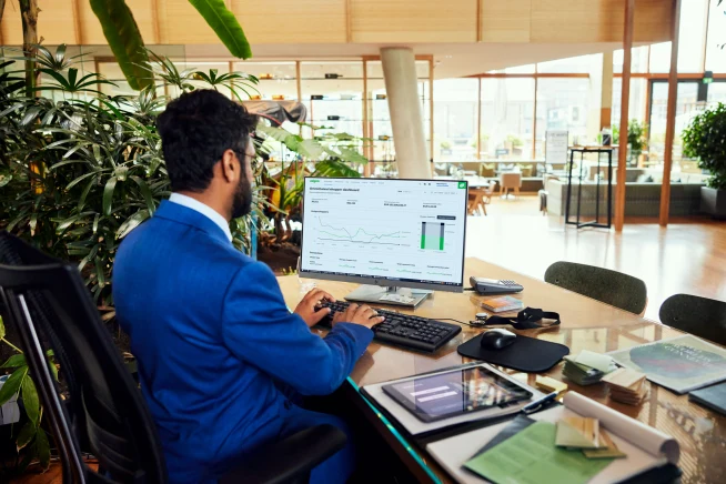 Un employé d'hôtel regardant un tableau de bord Adyen avec des graphiques de données.