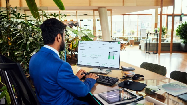 A hotel employee looking at a Adyen dashboard with data charts.
