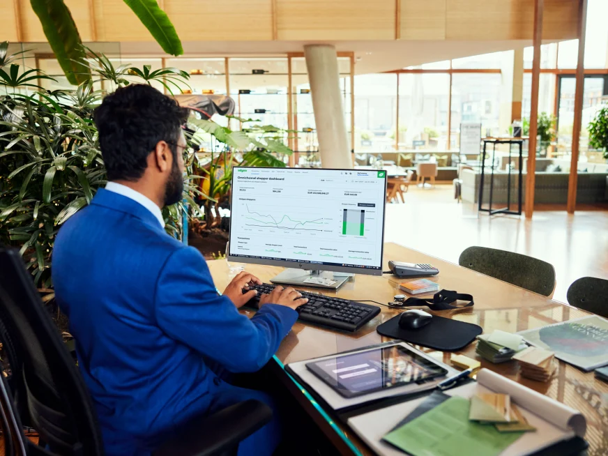 A hotel employee looking at a Adyen dashboard with data charts.