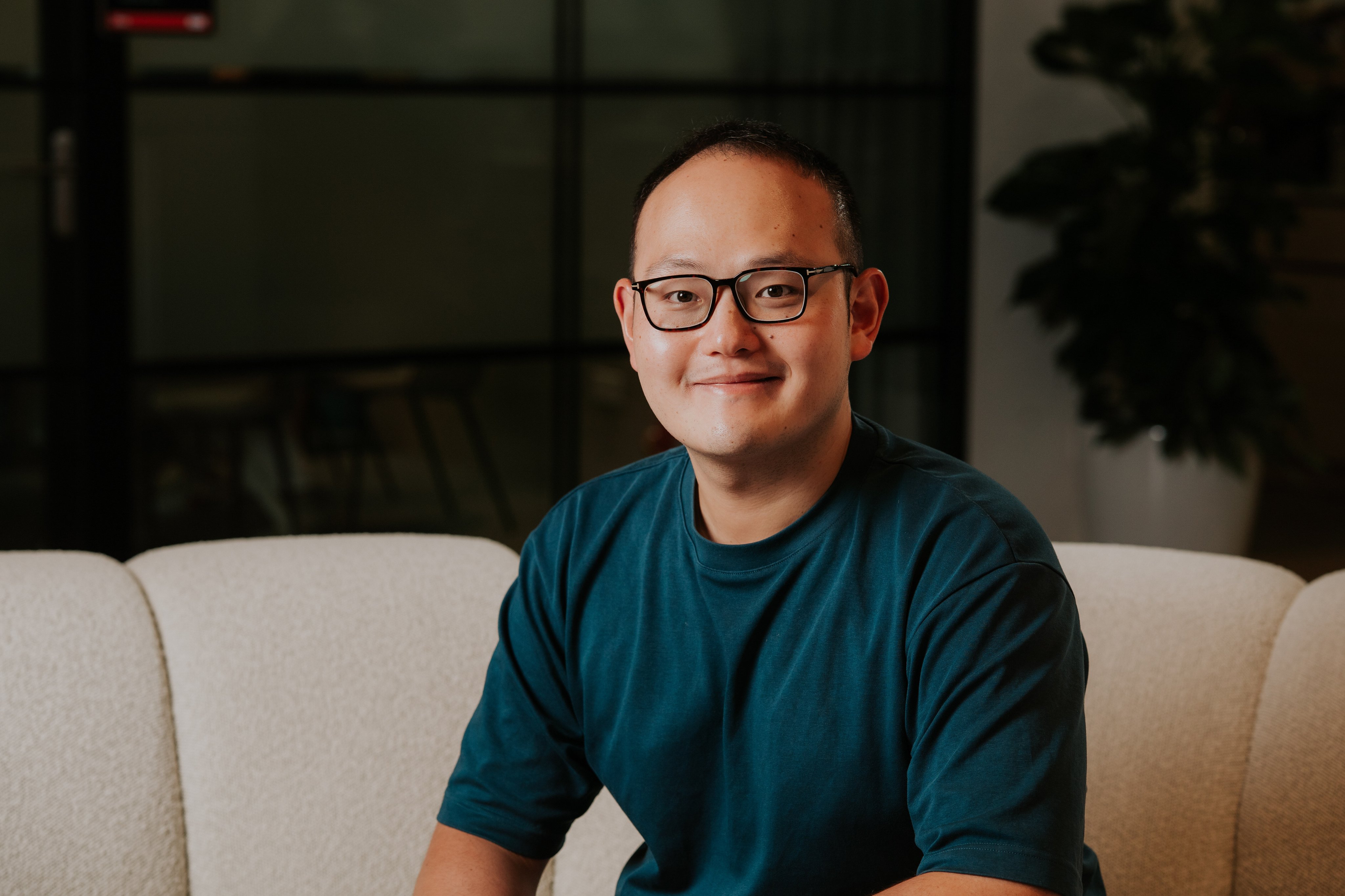 Adyen team member sitting on a sofa in the company office setting