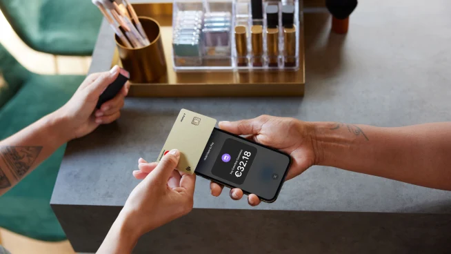 Shop owner and customer using Tap to pay on iPhone with creditcard