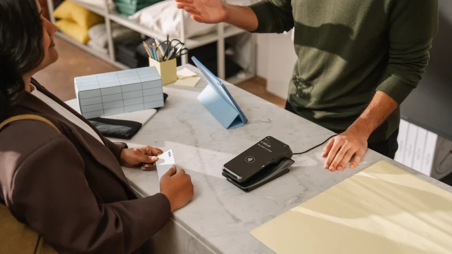 Woman paying with card at counter