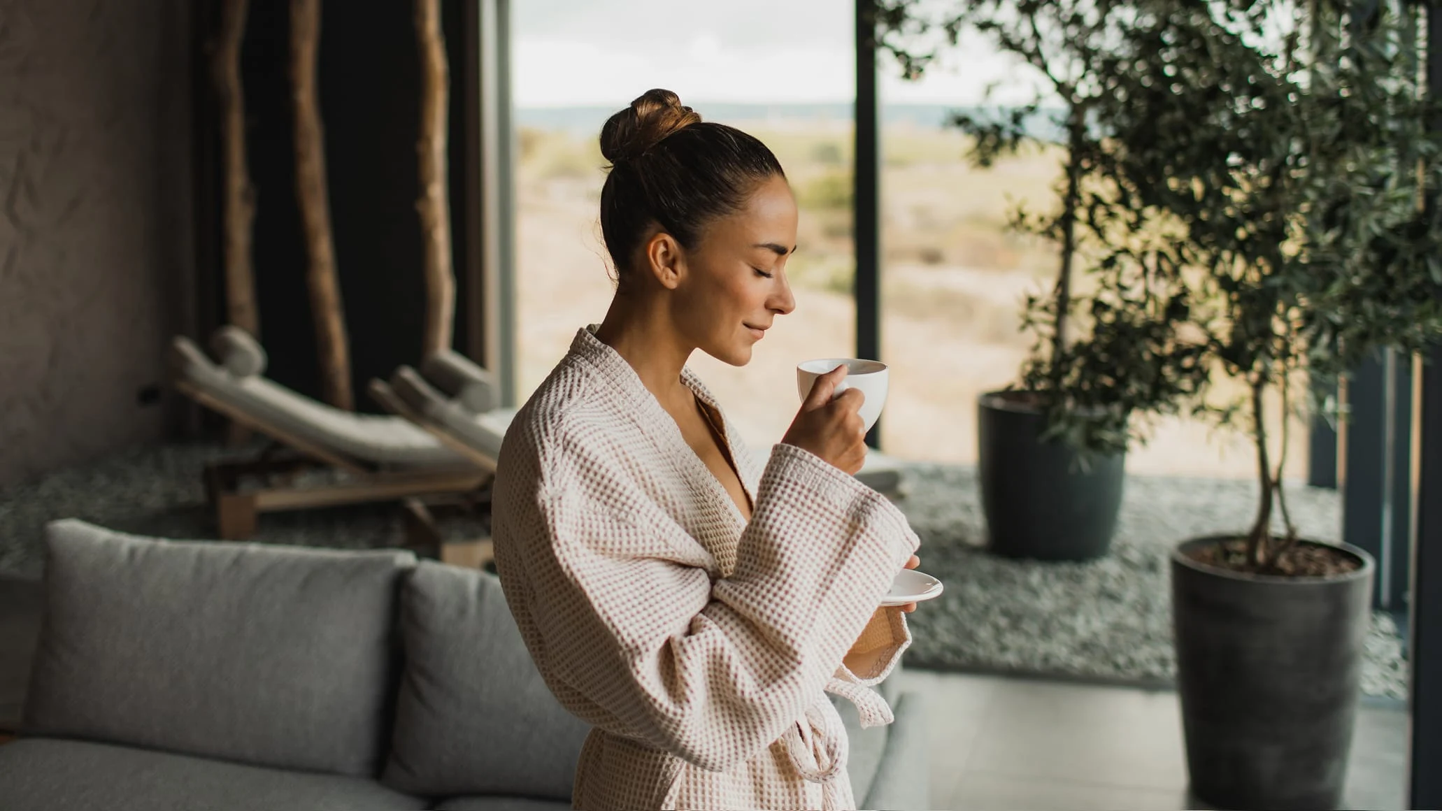 A woman in a cozy setting using her phone, with an Adyen terminal visible in the background.