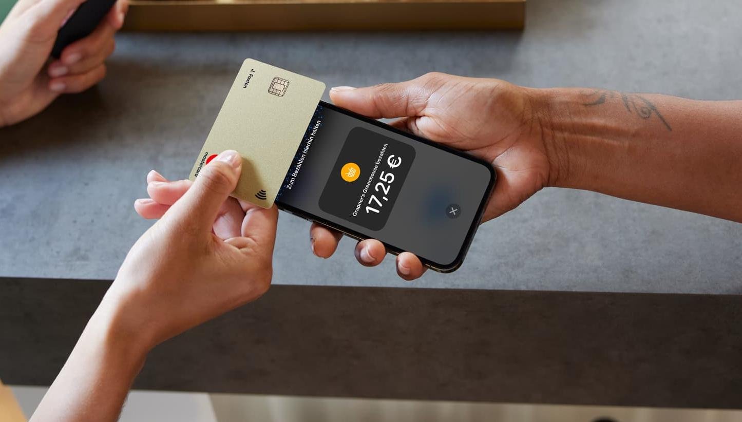Kunde zahlt mit Karte durch Tippen auf einem Iphone mit angezeigtem Betrag in Euro