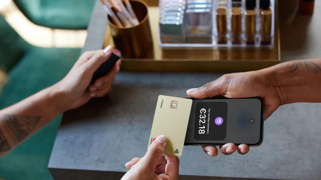 Shop owner and customer using Tap to pay on iPhone with creditcard
