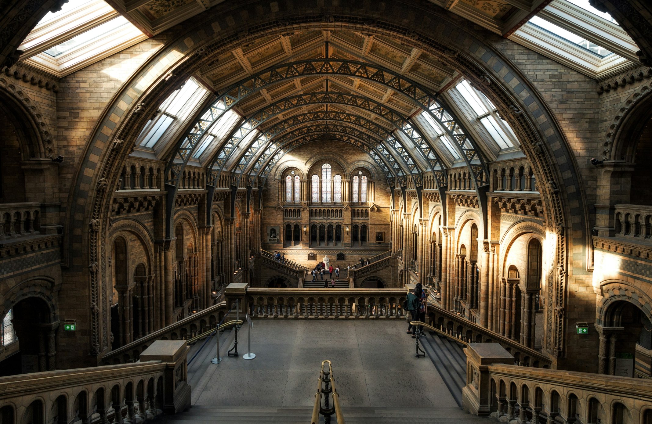 A historic indoor train station with a glass ceiling, stone walls, and people walking; payment by Adyen terminal.