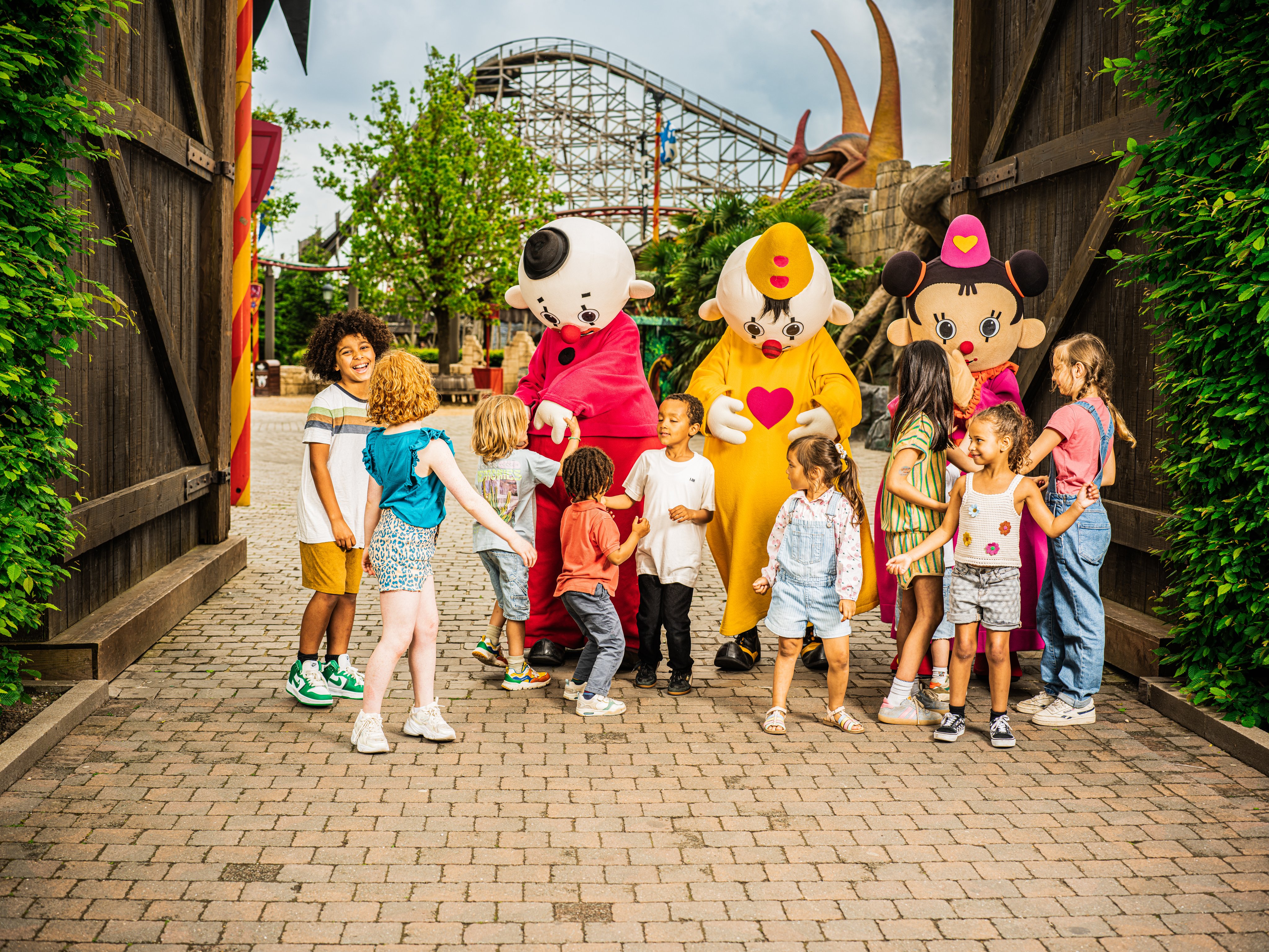 Kinderen bij een ingang met drie mascottes