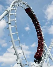 People riding a roller coaster on a themed amusement park ride.