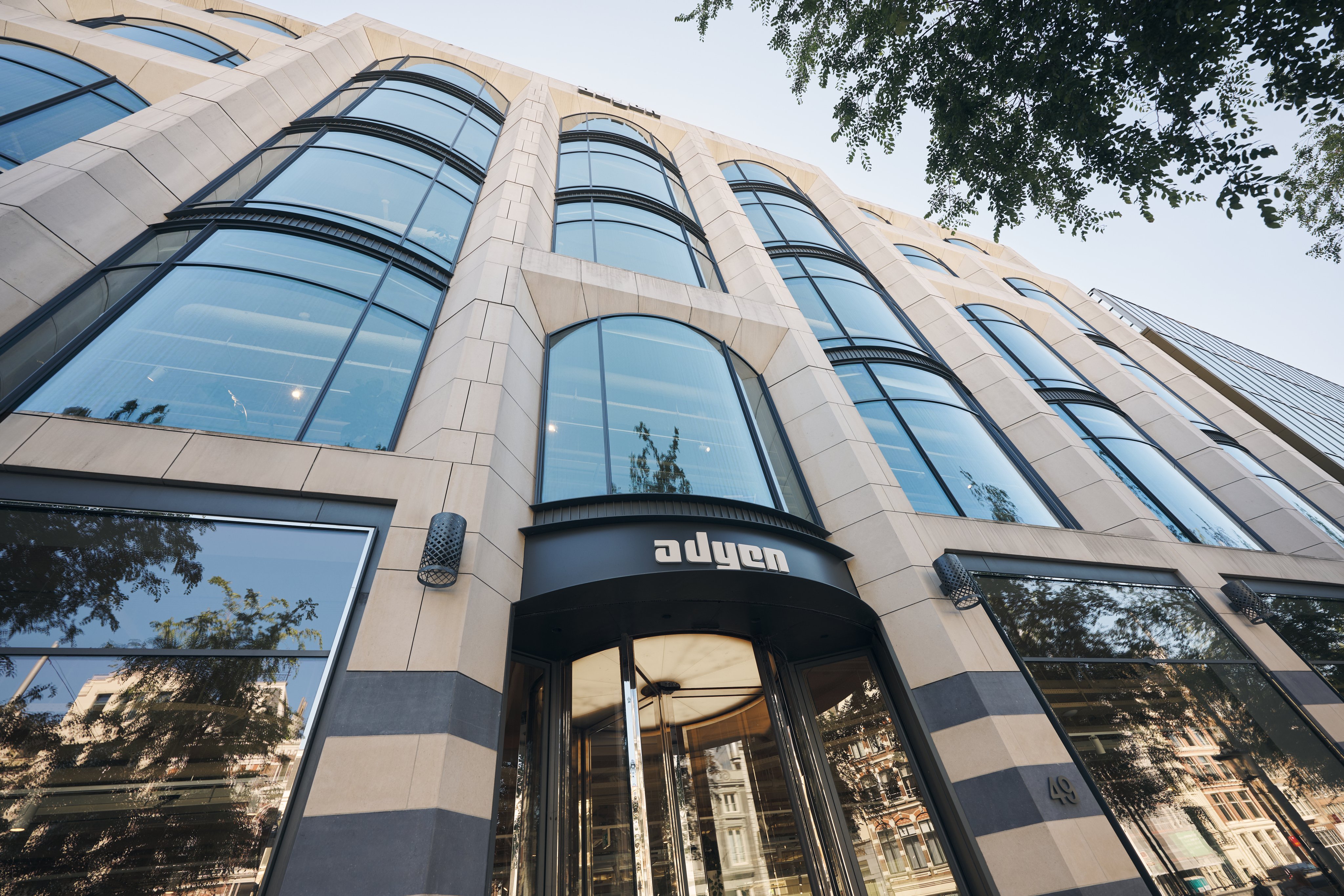 Modern building exterior with large glass windows and the Adyen logo above the entrance.