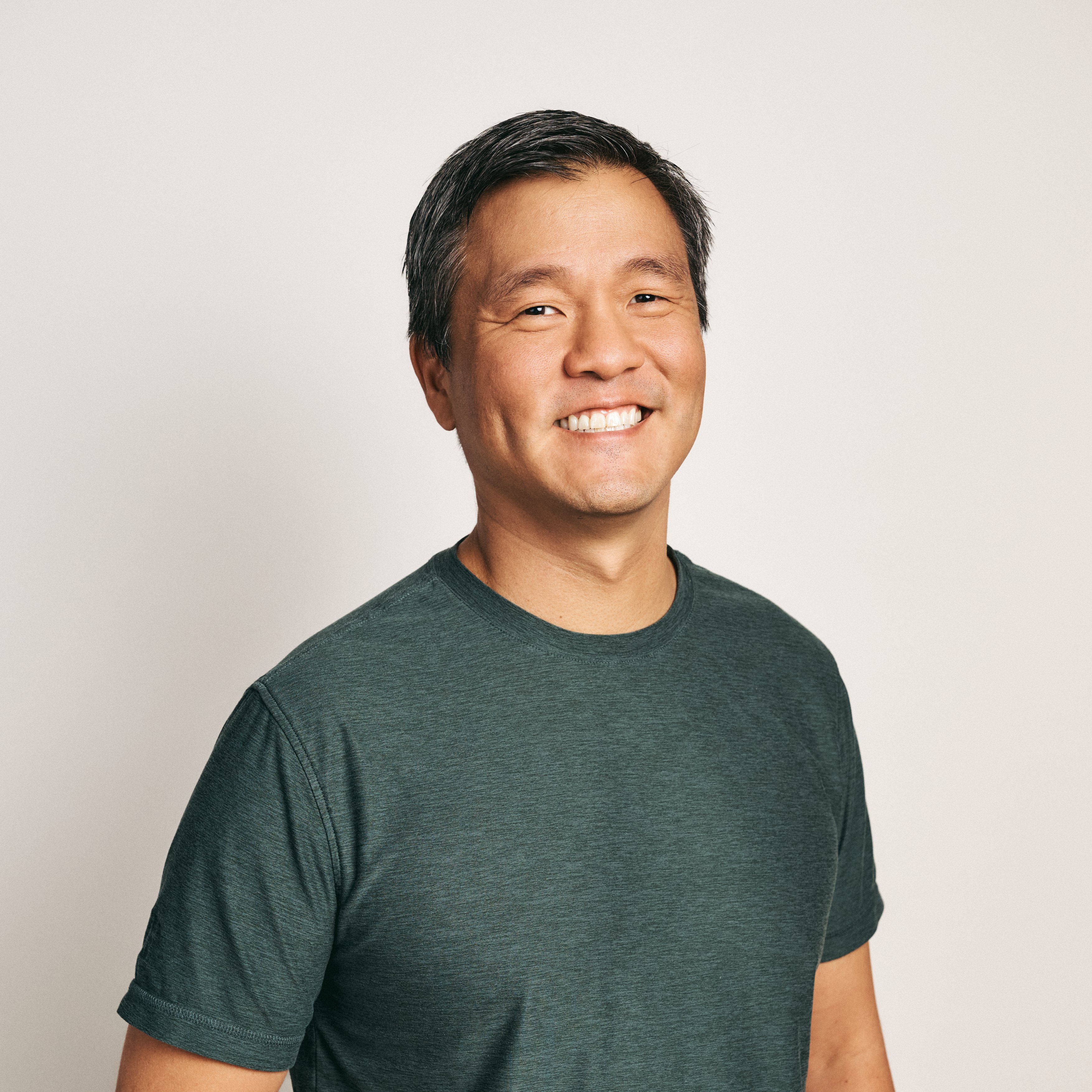 Adyen team member smiling in the office, wearing a casual T-shirt.