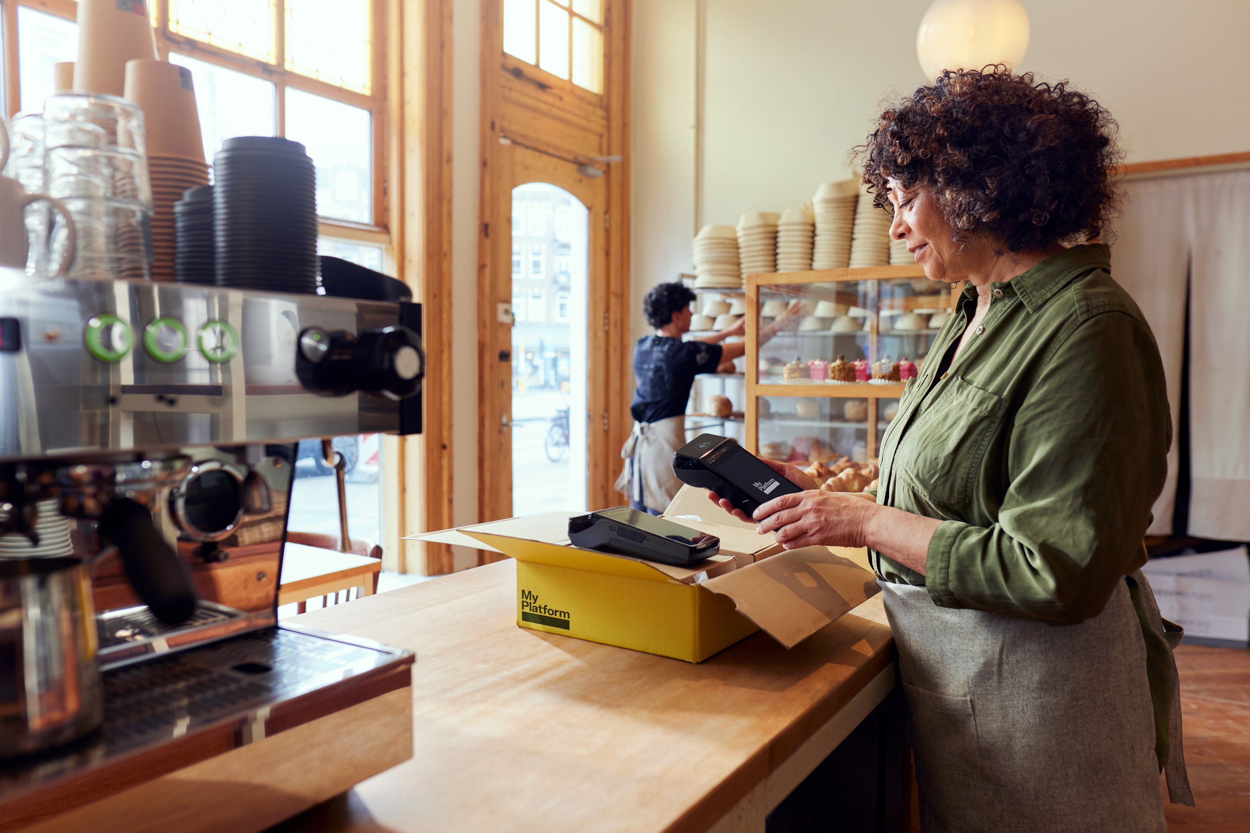 A coffee shop owner setting up and using an Adyen terminal through a SsaS platform for food & beverage.