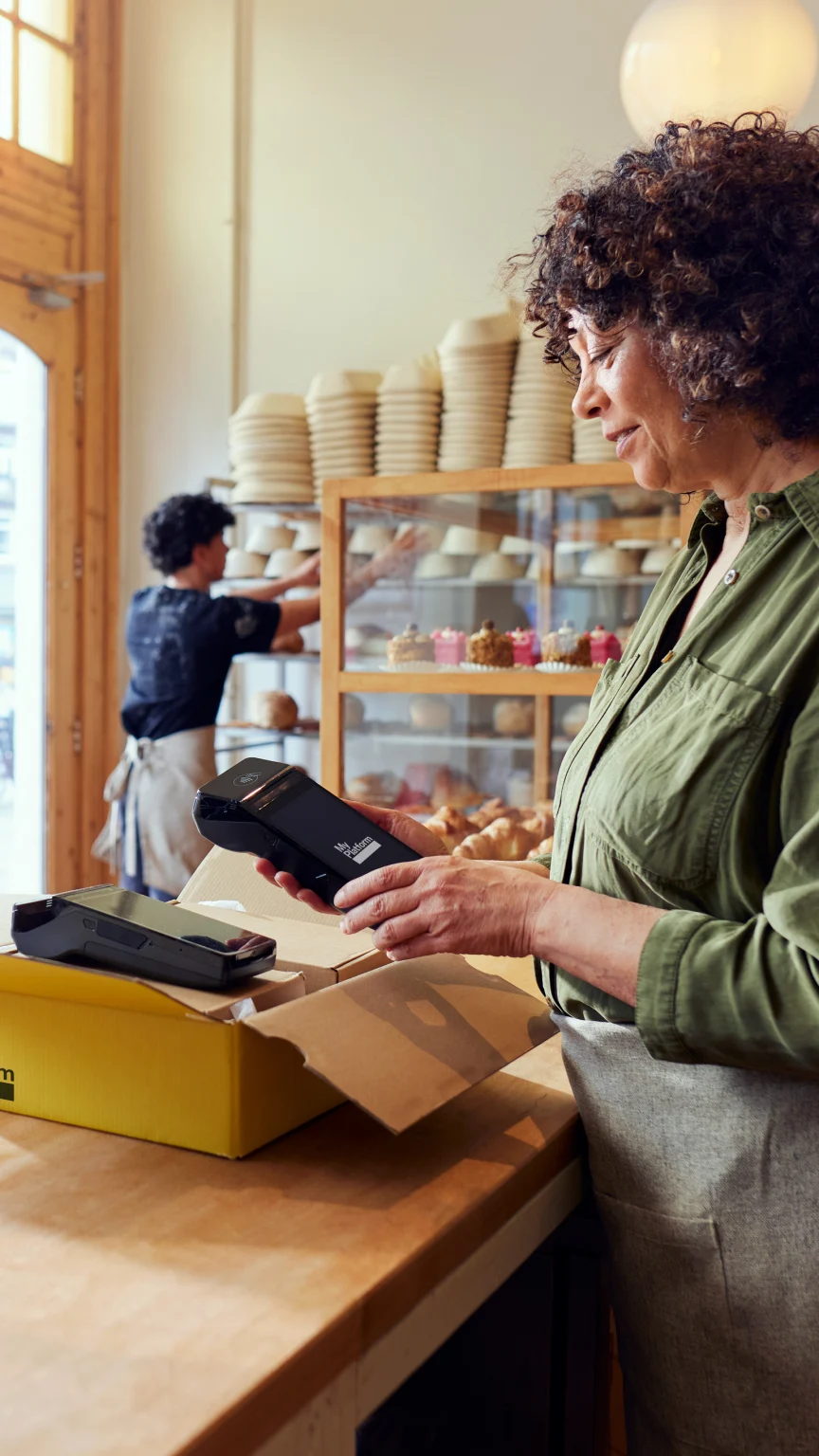 A coffee shop owner setting up and using an Adyen terminal through a SsaS platform for food & beverage.