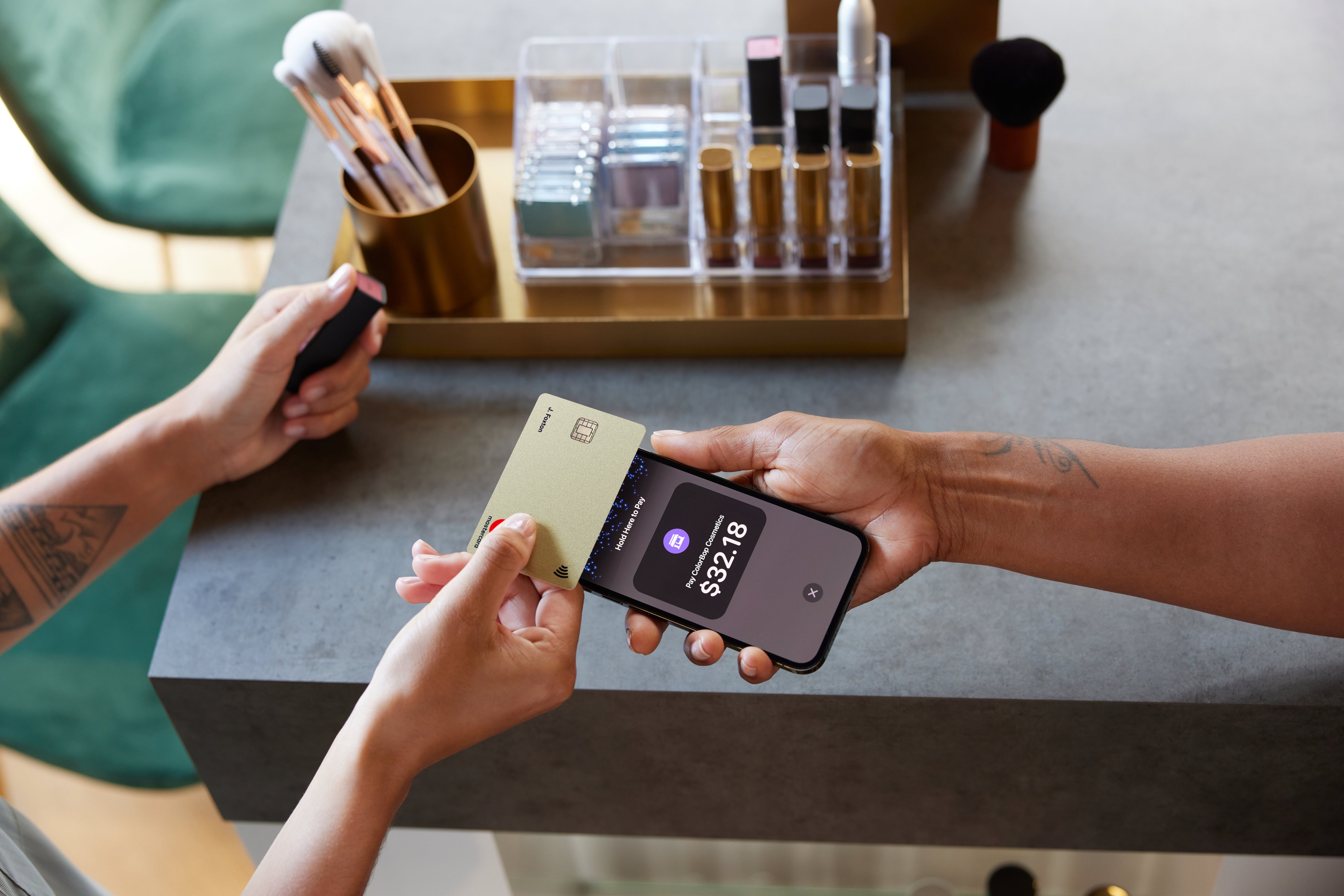 Beauty & cosmetics shop owner and customer using Tap to pay on iPhone with creditcard