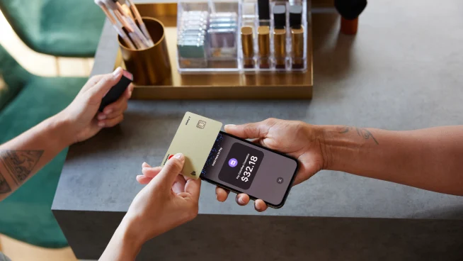 Beauty & cosmetics shop owner and customer using Tap to pay on iPhone with creditcard