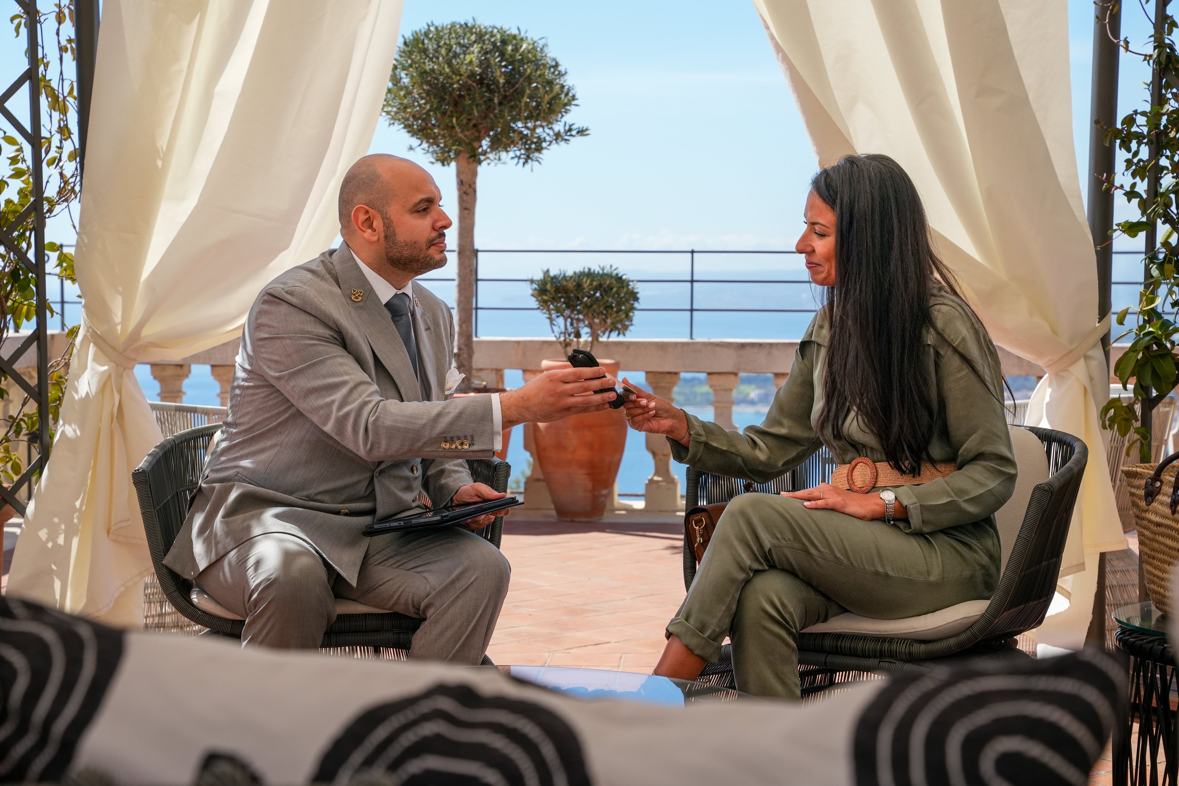 Business people exchanging a payment using an Adyen terminal on a balcony.