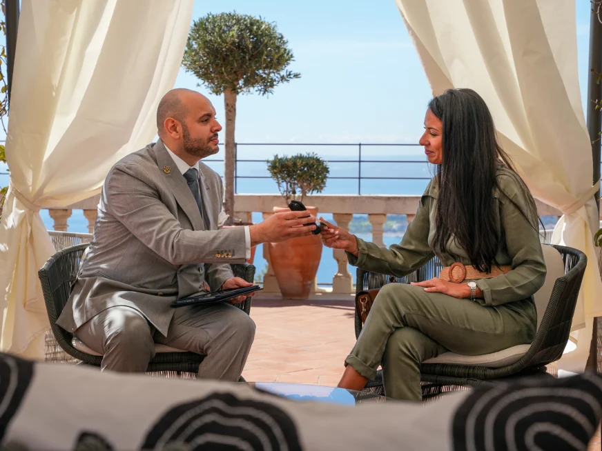Business people exchanging a payment using an Adyen terminal on a balcony.