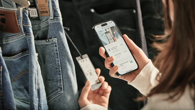 A customer using a mobile device to make a payment with an Adyen terminal.
