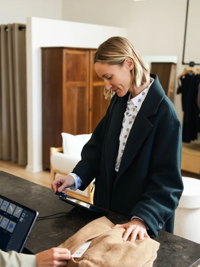 Adyen employees in the Adyen office assisting a customer with a payment transaction.