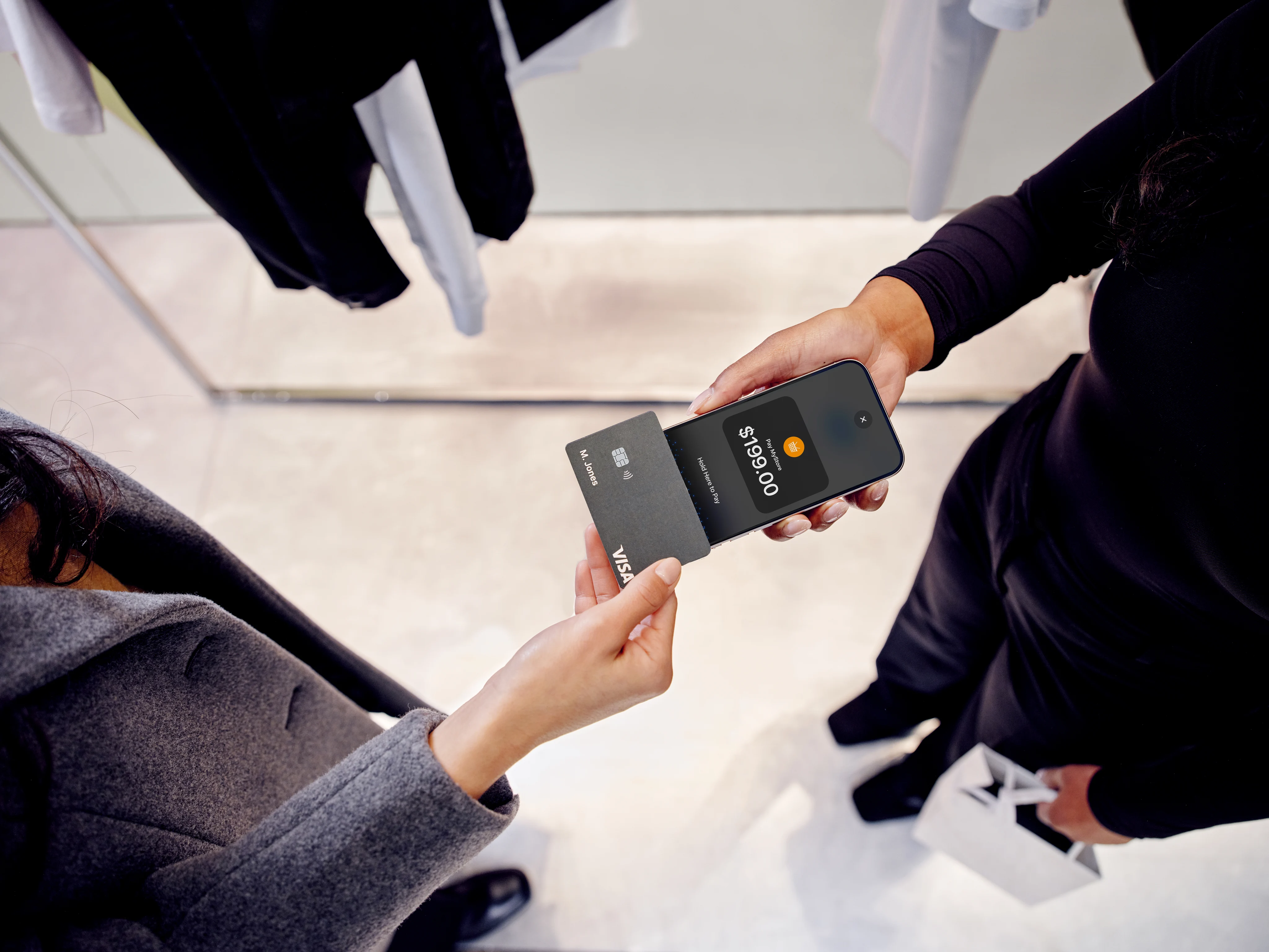 Business person receiving a digital payment via an Adyen terminal in a retail environment.